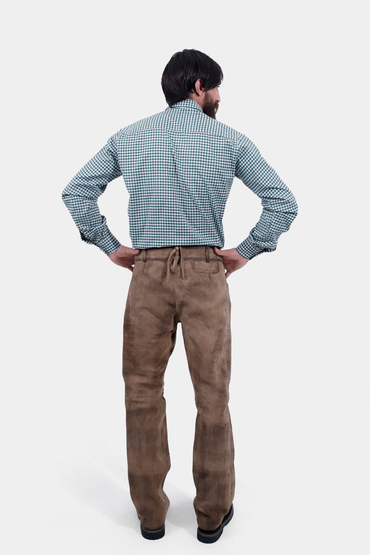 A back view of the man wearing the Addison Oktoberfest Lederhosen Long and green checkered shirt. His hands are on his hips, displaying the back details of the lederhosen.