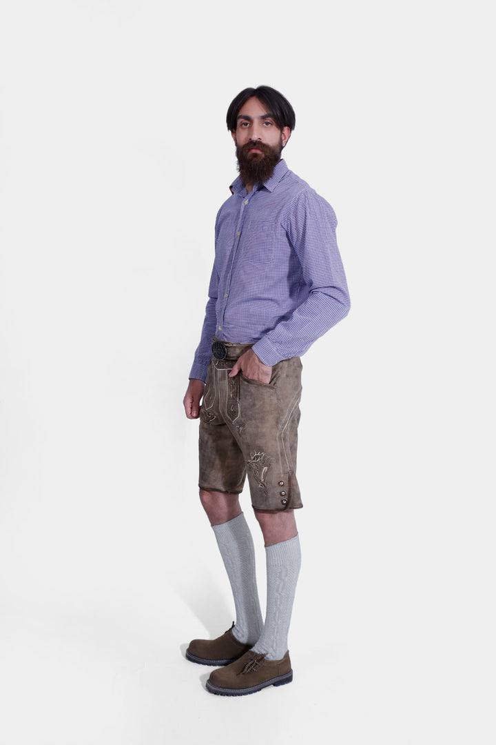 Side profile of man wearing Bodensee Lederhosen with blue checkered dress shirt, and knee-high socks.