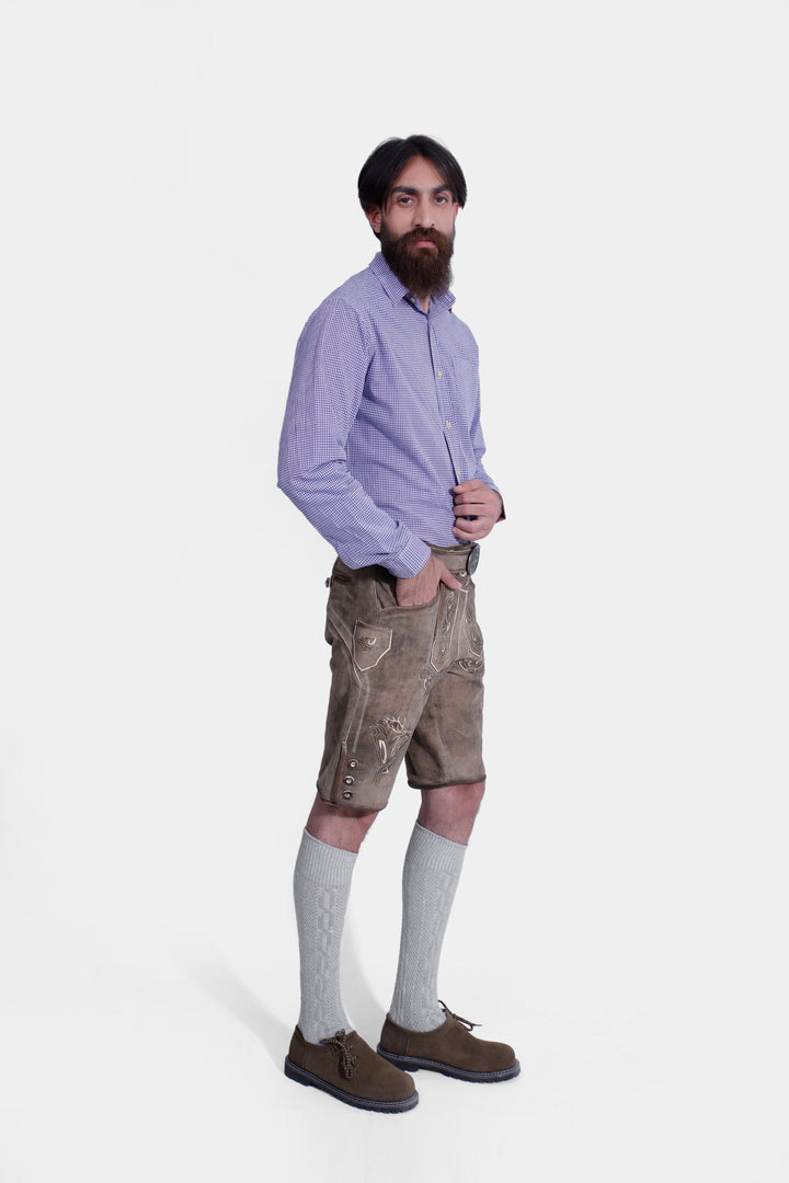 Side profile of man wearing Bodensee Lederhosen with blue checkered dress shirt, and knee-high socks.