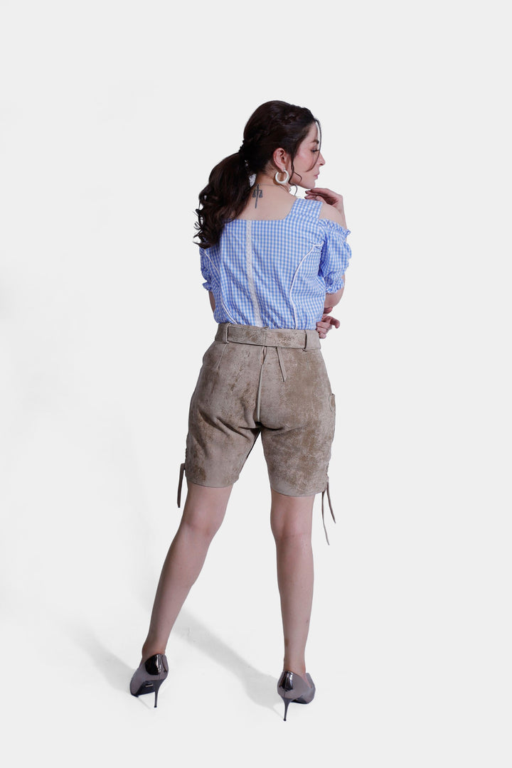 Back view of a woman wearing beige Desert Sand Lederhosen, focusing on the detailed back pockets and traditional style.