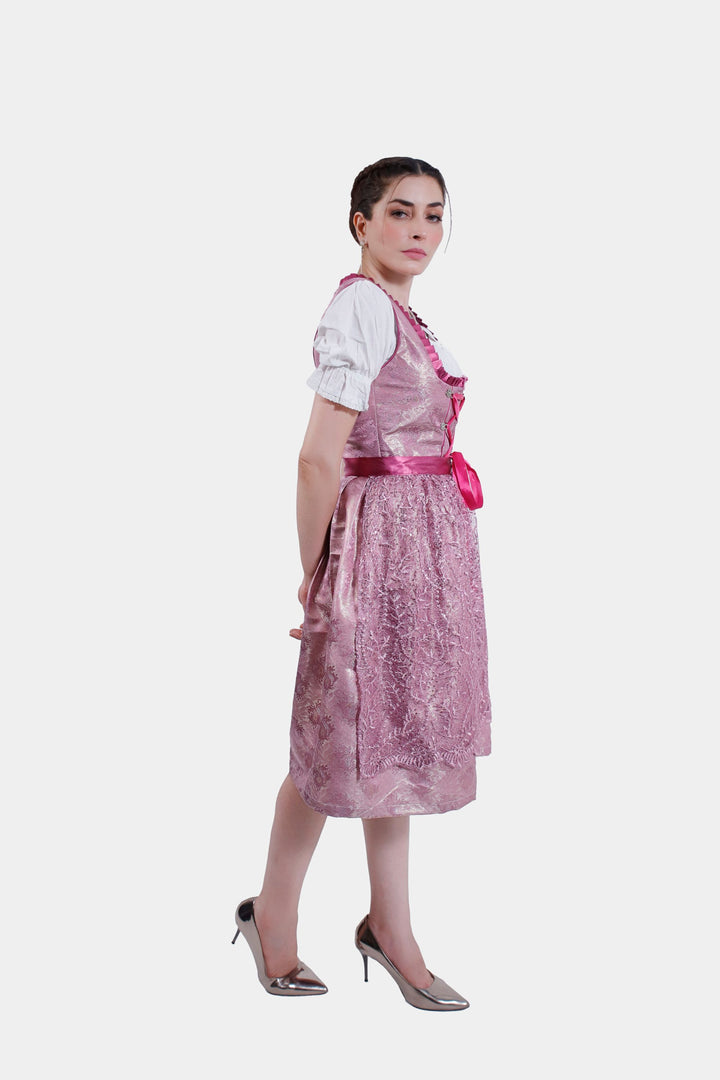 Woman standing confidently in the Dirndl Christiane, displaying the full outfit with its detailed lace bodice and satin apron.