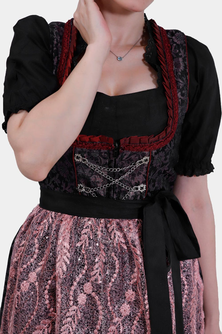 Close-up of a Dirndl Franka showing the elaborate lace detailing on the apron and the rich velvet texture of the bodice.