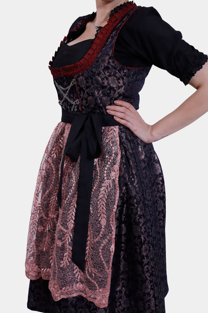 Right side view of a woman wearing a Dirndl Franka, highlighting the tied black bow and lace-trimmed skirt.