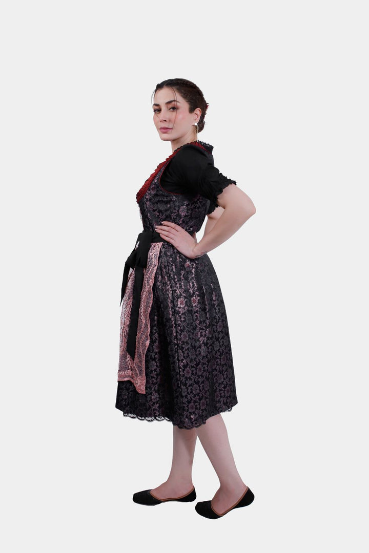 Back view of a woman wearing a Dirndl Franka, highlighting the tied black bow and lace-trimmed skirt.