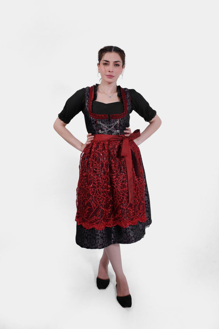 Full-length front view of a woman posing in the Dirndl Kelly, showing off the detailed lace skirt and contrasting black blouse.