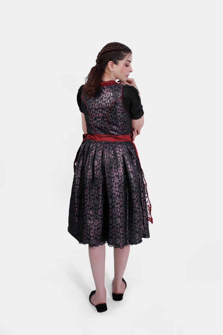 Back view of a woman wearing the Dirndl Kelly, focusing on the lace-up detailing and the fullness of the skirt.