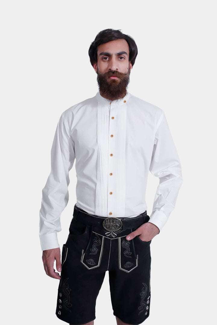 Close-up of a man in the Elgort Lederhosen Outfit, showing the upper half of his body with a white shirt and the top part of the black leather Lederhosen with detailed white embroidery.