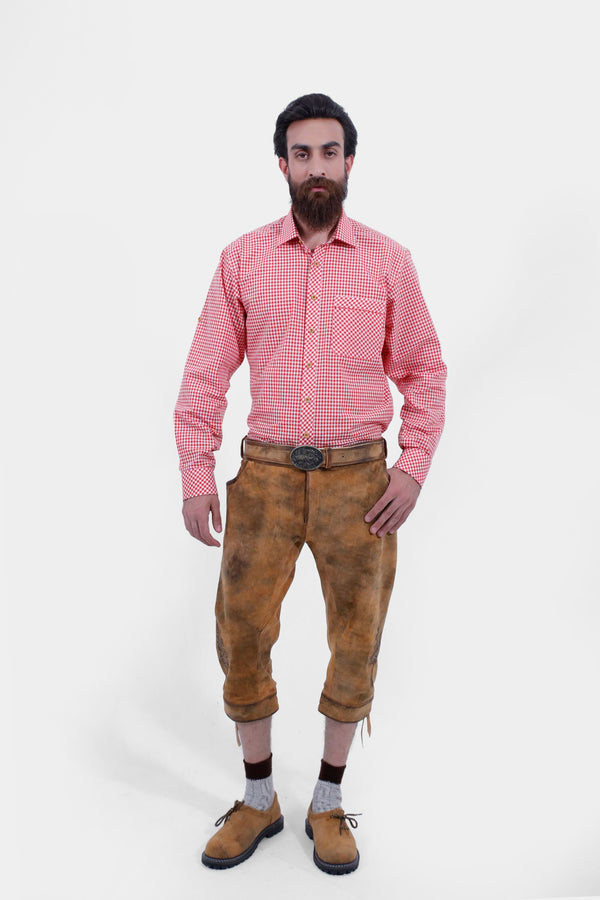 Full view of brown Eltz Bundhosen with red check shirt and brown and grey socks and tan brown shoes, worn by a man against a white background.