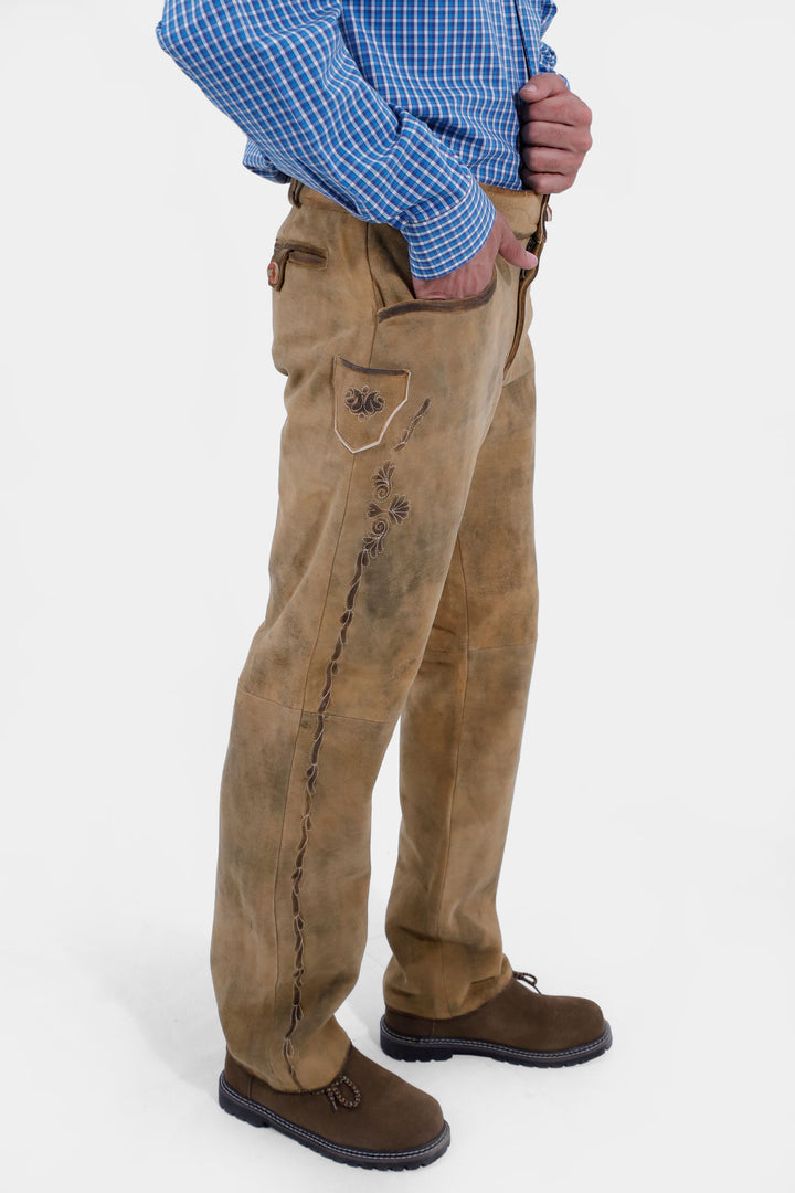 Another angle showing the Goretzka lederhosen, focusing on the embroidered pocket and side details, with the man's hand in the pocket.