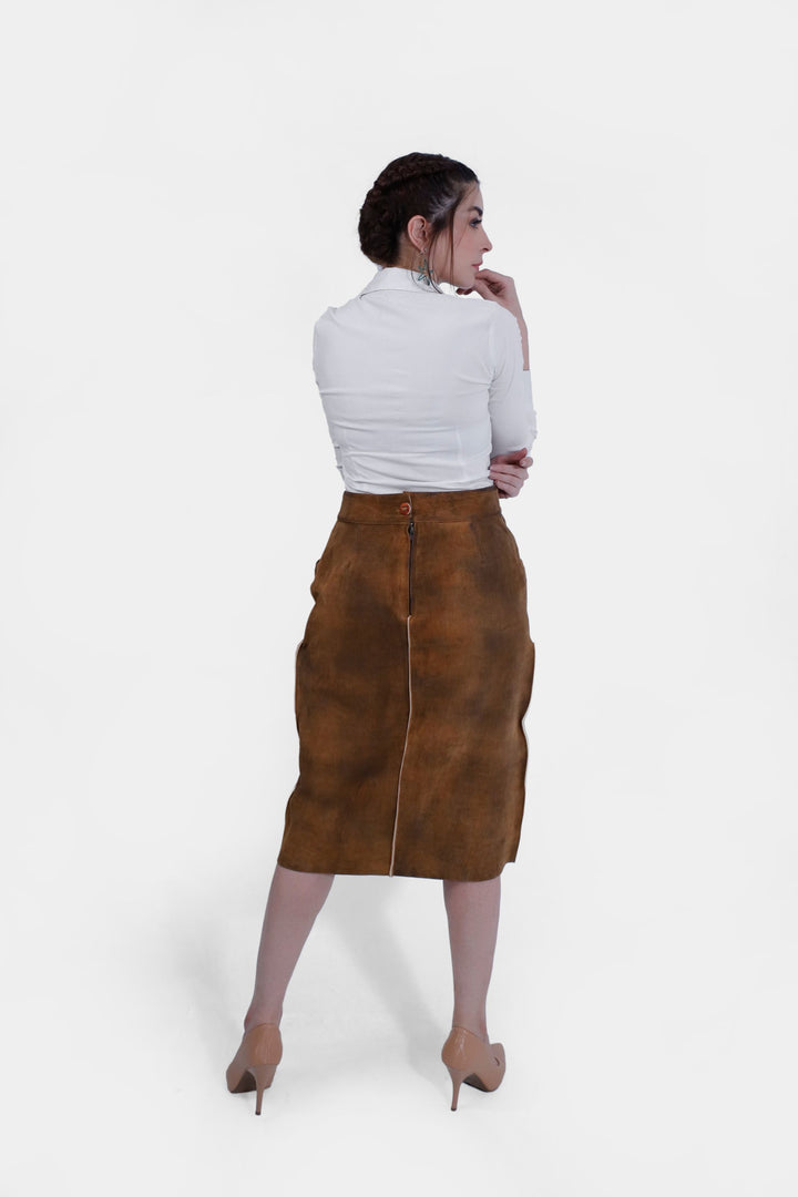 Back view of a woman wearing the Griessee Lederhosen Skirt in brown leather, displaying the skirt's rear design and the zipper closure.