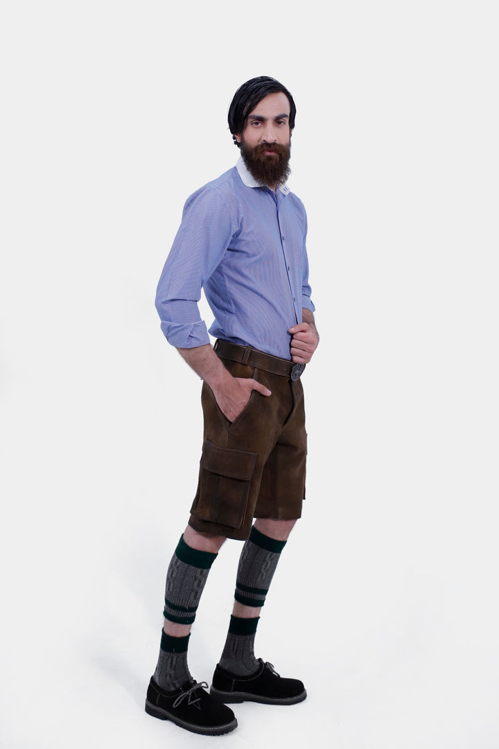 Side profile of a man in Hallstatt Cargo Lederhosen, emphasizing the brown leather shorts' design and fit, paired with a blue checkered shirt.