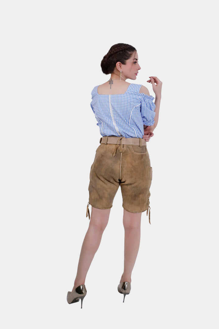 Rear view of Helene Lederhosen, showcasing the back fit and style of the shorts paired with the blue checkered blouse.