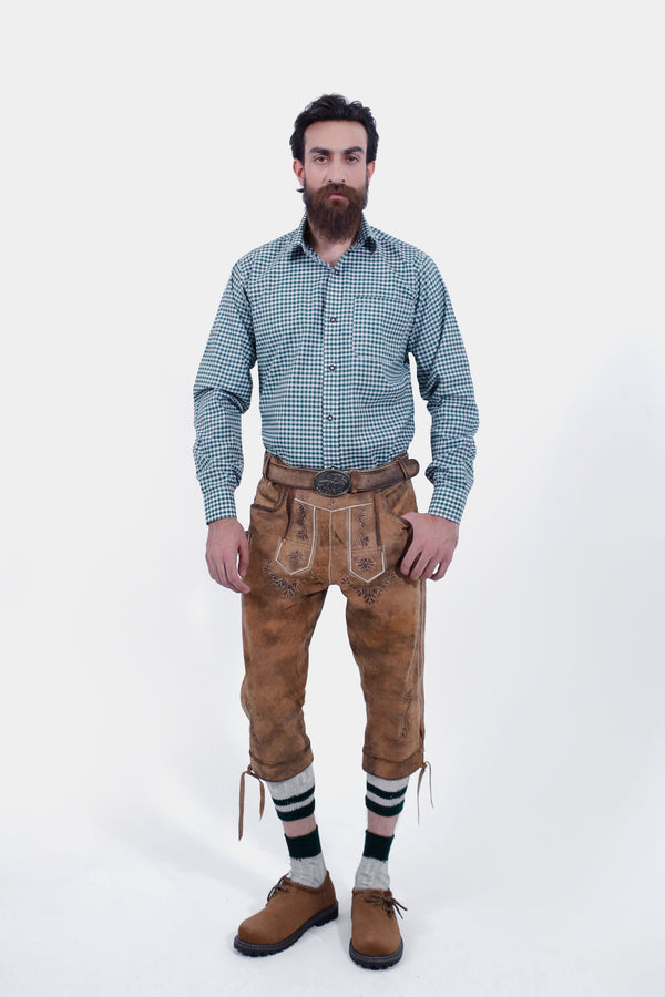 Man wearing a green checkered shirt and Hesse Bundhosen, standing straight. The brown leather pants have detailed floral embroidery on the front, side pockets, and are paired with traditional Bavarian shoes and green-striped socks.