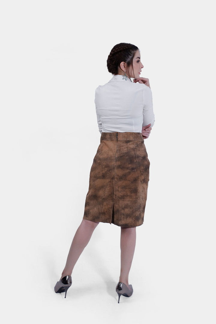 Back view of a woman wearing the IRINA Lederhosen Skirt in brown leather, displaying the skirt's rear design and the zipper closure