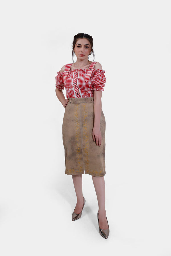 Model wearing a Kollwitz Lederhosen Skirt in sandy tan buck skin leather, paired with a red and white checkered blouse, front view.