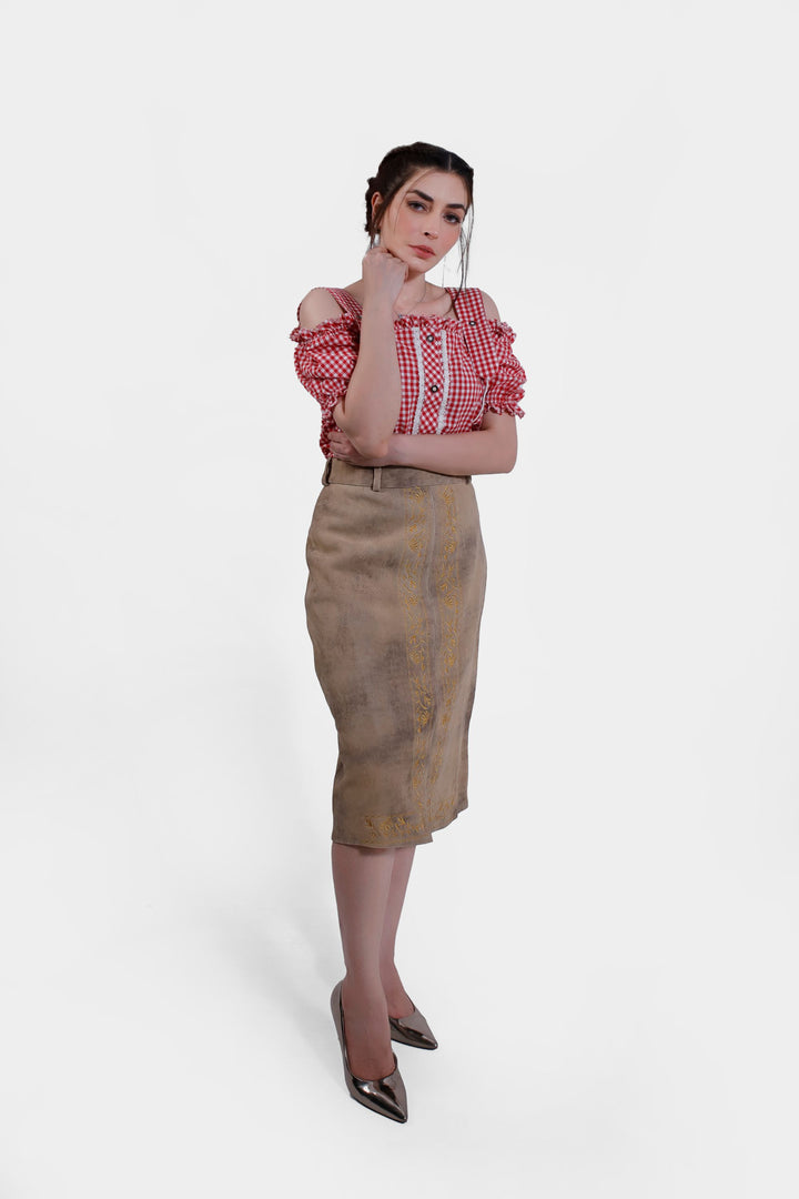 Full front view of the model wearing the Kollwitz Lederhosen Skirt in sandy tan buck skin leather, paired with a red and white checkered blouse.