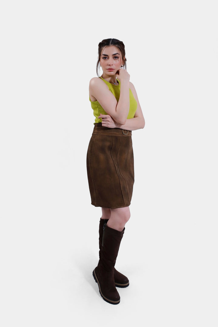 Woman wearing the Leni Lederhosen Skirt in Rustic Oak, with her hand on her chin, emphasizing the skirt’s elegant fit and stylish appeal.