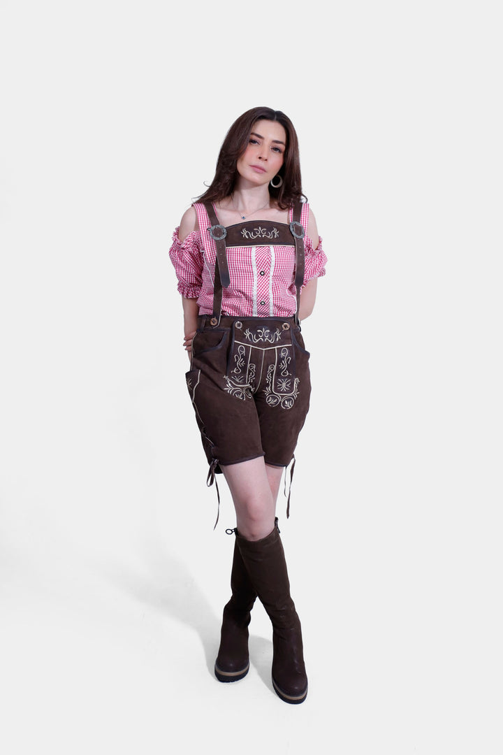 Full-length view of a woman in brown Margarethe Lederhosen and tall brown boots, striking a pose with hands on hips.