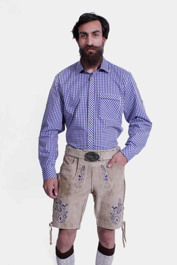 Close-up view of a man in a Mookie Lederhosen Outfit, highlighting the blue and white checkered shirt and tan leather lederhosen with blue embroidery and a decorative belt buckle.