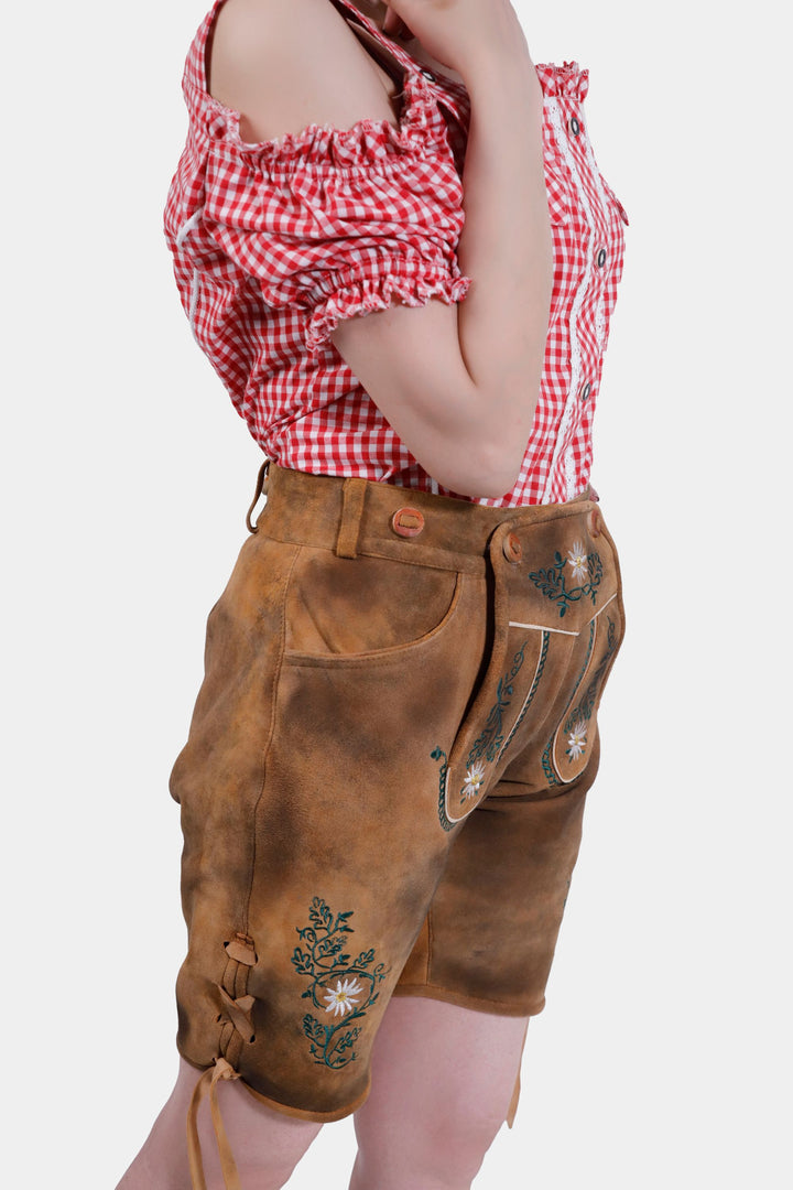 Woman posing in Munich Majesty Lederhosen, emphasizing the and the elegant embroidery detail.