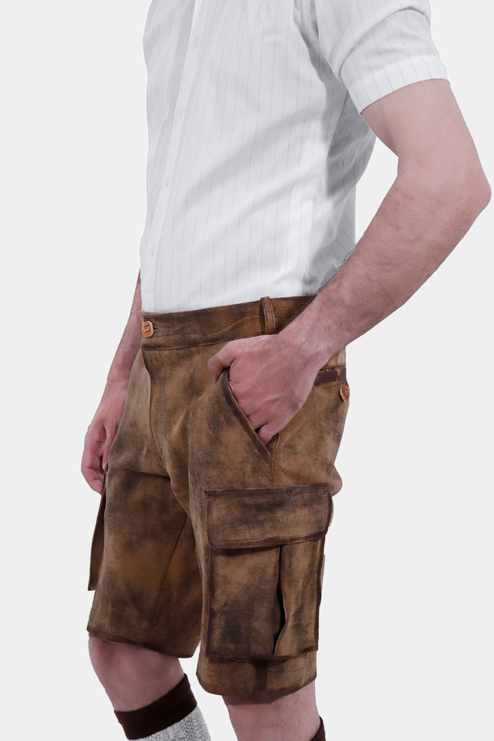 Close-up side view of Snowbird Cargo Lederhosen worn by a man, emphasizing the quality leather, pocket details, traditional socks, and brown shoes.