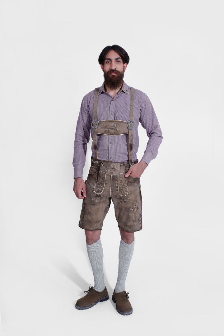 Man standing in Raphael Lederhosen with checkered dress shirt, brown shoes, and gray knee-high socks, full body shot.