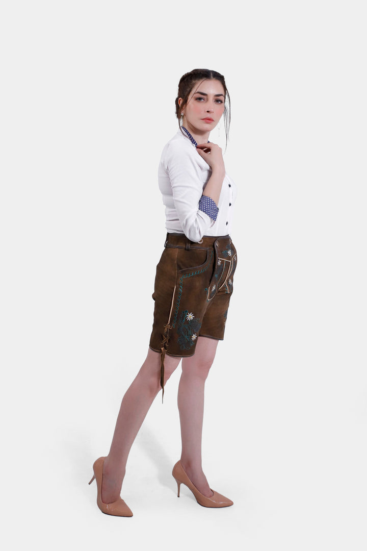 Side profile of a woman in Romy Schneider lederhosen, featuring the side knife pocket and the detailed embroidery.