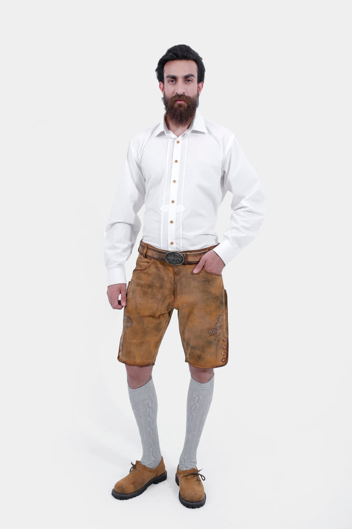 Full-body front view of the man wearing the Rothenburg Lederhosen. The traditional design of the lederhosen is complemented by the white shirt and grey knee-high socks. kurze Lederhosen für Männer