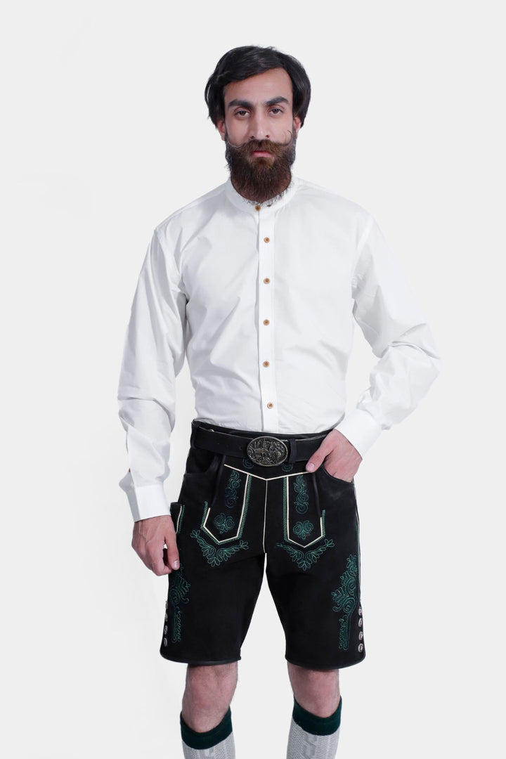 Close-up view of a man in a Schümann Lederhosen Outfit, showcasing the white long-sleeved shirt with button details and black leather lederhosen with green embroidery and a decorative belt buckle