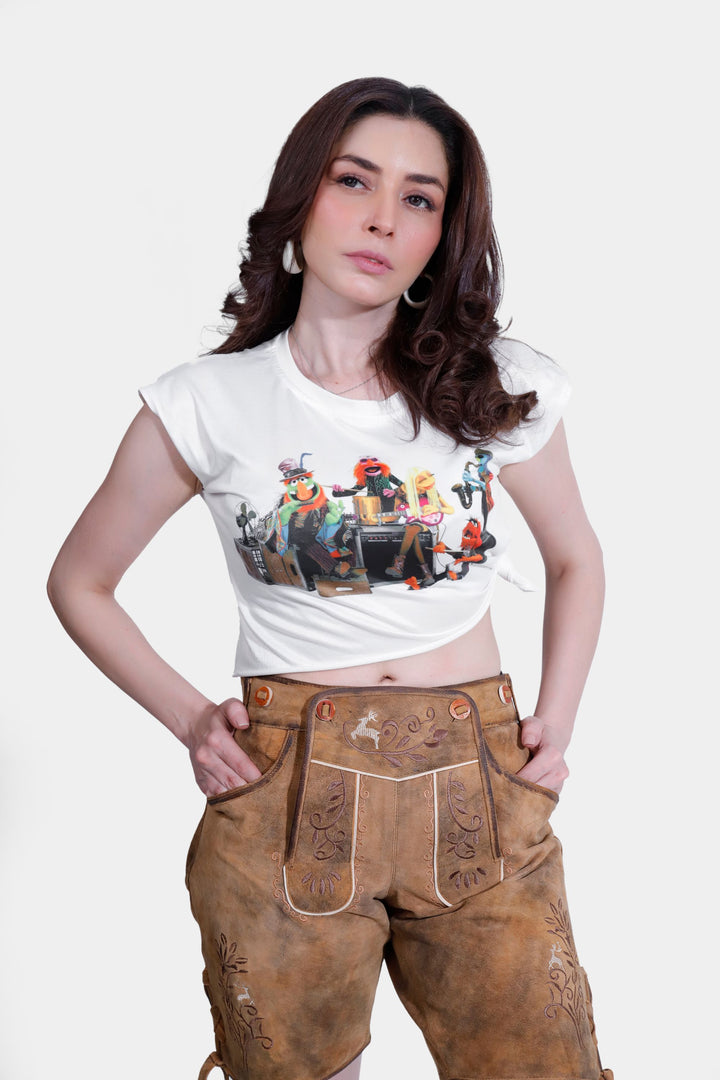 Woman posing in Stefani Lederhosen with hands on hips, showcasing the detailed floral and fauna embroidery on the suede leather.