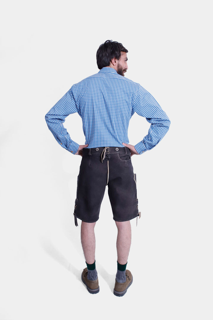 Rear view of a man wearing the Timothée Lederhosen Outfit, showing the back of the blue checkered shirt and the black leather Lederhosen with a back tie detail.