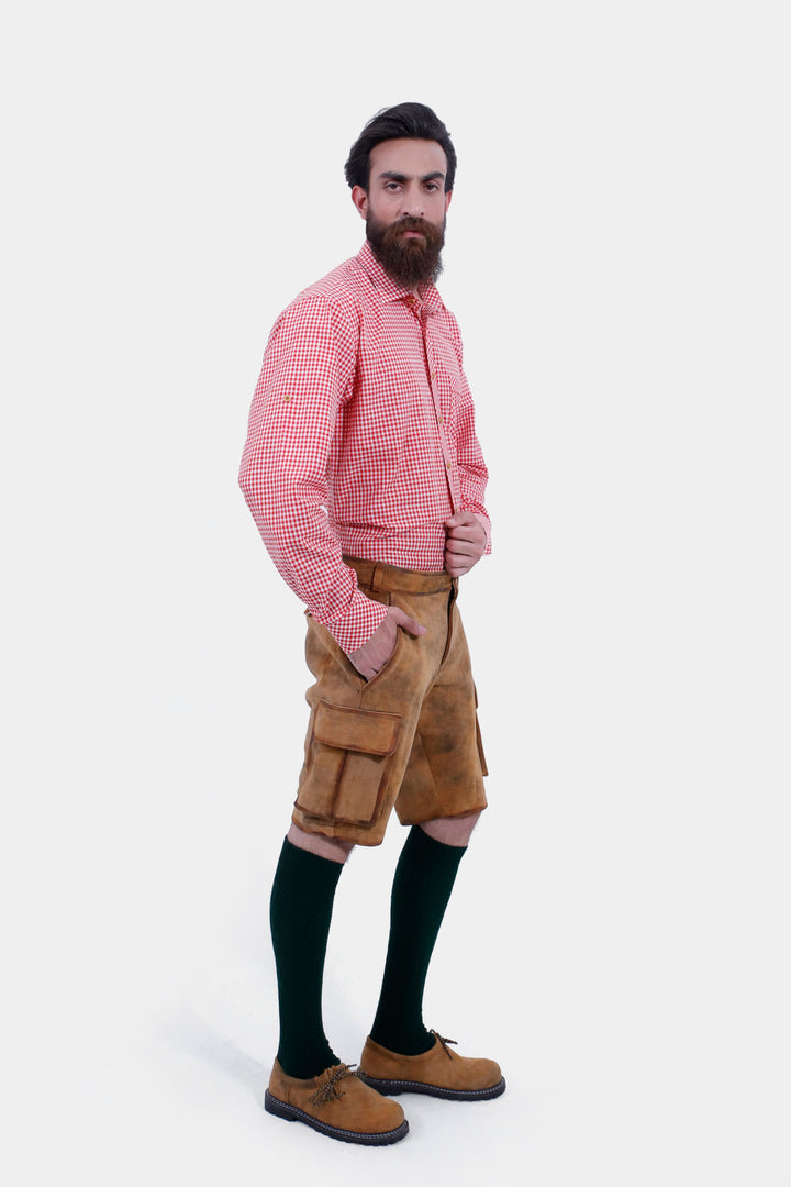 Side profile of a man in Wagner Cargo Lederhosen and a red checkered shirt, highlighting the fit and functional side pockets of the light brown leather shorts.