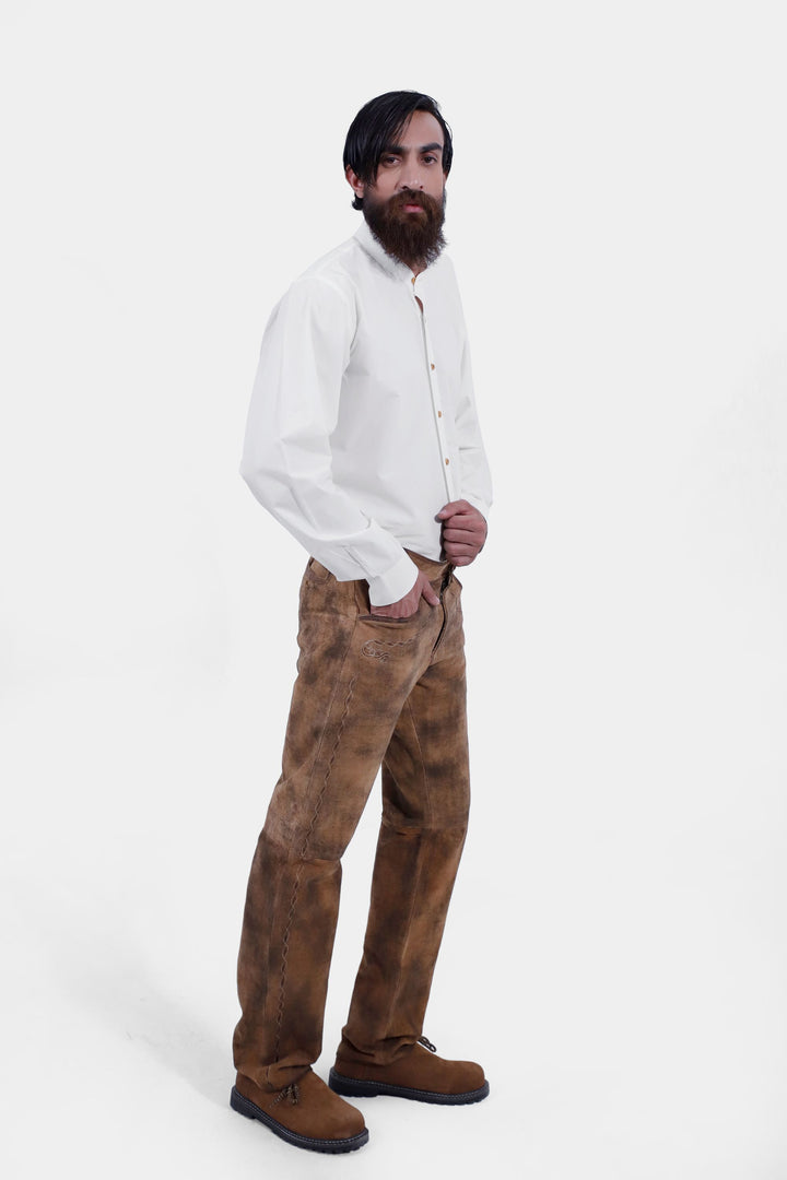 Profile view of a person wearing Zugspitze Lederhosen Long Pant with detailed embroidery, paired with a white button-up shirt.