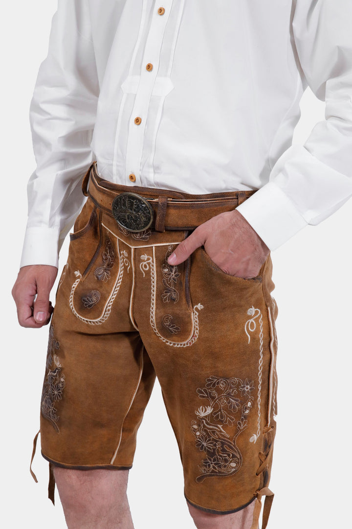 Close-up side view of Freud Lederhosen worn by a man, focusing on the texture and embroidery of the fabric.