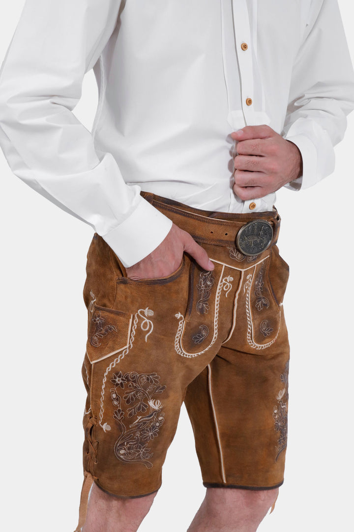 Close-up side view of Freud Lederhosen worn by a man, focusing on the texture and embroidery of the fabric.