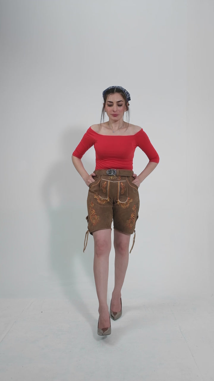 Fashion video showcasing a woman modeling traditional brown Queen Victoria Lederhosen with detailed embroidery, paired with a red shirt