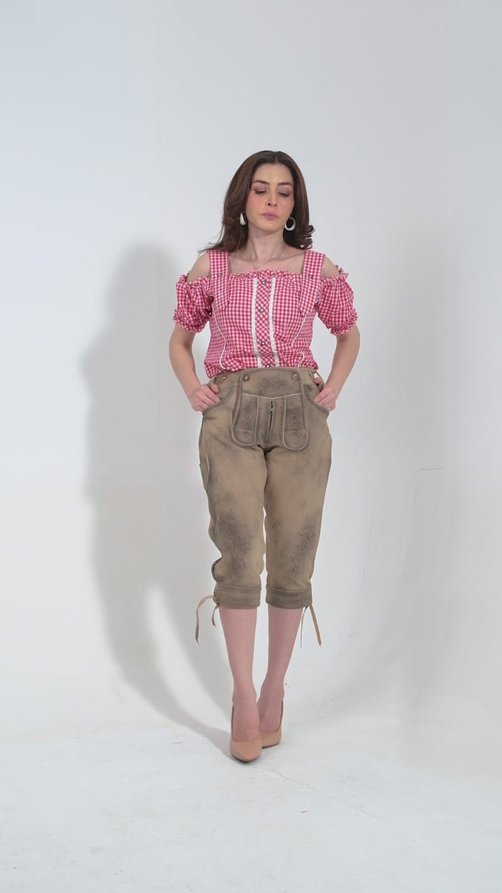 Video showcasing the Garm Lederhosen Outfit for women in beige brown color. The video highlights the premium goat suede leather material, intricate natural color embroidery on the bib and legs, two front pockets, a side knife pocket, and the stylish brown horn buttons on the bib and cuffs. The adjustable waistband at the back ensures a snug fit. Note that matching belts and suspenders are not included, allowing for personalized styling.